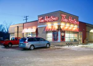 a minivan parked in front of a tim hortons restaurant at NEW Stunning Large Gorgeous Space Downtown Parking Coffee in Moose Jaw
