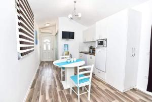cocina con armarios blancos, mesa y sillas en Apartments with a parking space Vir - 22542, en Vir
