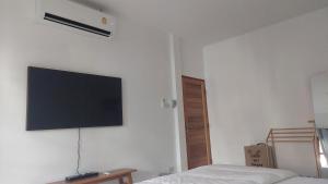 uma televisão de ecrã plano pendurada na parede de um quarto em baan Thankhun em Ban Rangeng