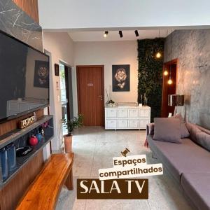 ein Wohnzimmer mit einem Sofa und einem Flachbild-TV in der Unterkunft Kim Casa BH in Belo Horizonte
