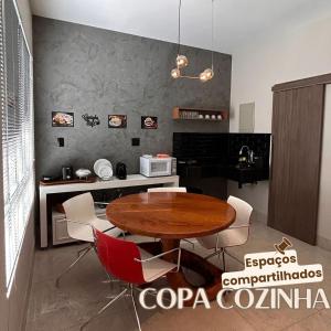 a kitchen with a wooden table and red chairs at Kim Casa BH in Belo Horizonte