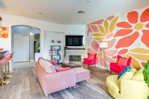 ein Wohnzimmer mit rosa und gelben Möbeln und einem Kamin in der Unterkunft Indio Couples Retreat with Pool, Hot Tub and Patio in Indio