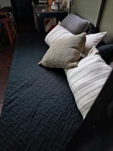 3 almohadas sentadas en una cama en una habitación en CABAÑA MI PAZZ camino al cuadrado en Córdoba