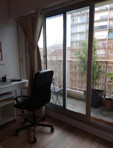 a desk and a chair in a room with a window at Sympa-Appart in Paris