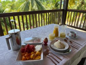a table with a plate of fruit and rice on it at Ecolodge Batel Alagoas in Coruripe