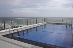 a swimming pool on top of a building with the ocean at In the heart of Colombo 2 Bedrooms Apartment in Colombo