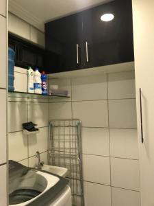 ein Bad mit einem Waschbecken und einem schwarzen Schrank in der Unterkunft Quarto no Dubai Residence in São Luís