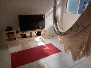 a living room with a flat screen tv and a hammock at Espaço Jeito de Casa Hospedagem em Quarto Compartilhado in Recife
