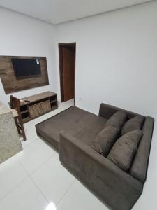 a living room with a couch and a flat screen tv at Bahia Trip Flats in Lençóis