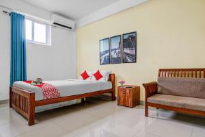 1 dormitorio con 1 cama y 1 silla en OYO Flagship 90284 Majestic Stays en Kakkanad