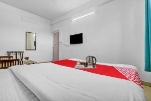 - un grand lit blanc avec une couverture rouge dans l'établissement OYO Flagship 90284 Majestic Stays, à Kakkanad