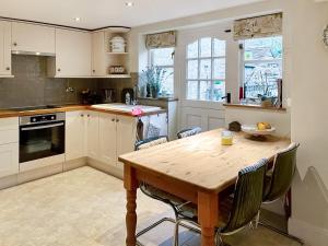 a kitchen with a wooden table and chairs at Mill View Cottage in West Stour