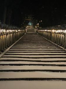 un puente cubierto de nieve por la noche con luces en Kannabi Ikomayama Hotel en Ikoma