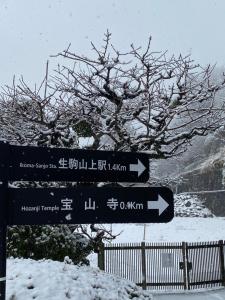 a snow covered street sign in front of a tree at Kannabi Ikomayama Hotel in Ikuma