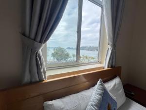 カットバ島にあるLàng Chài Hotel & Restaurantの水辺の景色を望むベッドルームの窓