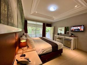 a hotel room with a bed and a television at The Taman Ayu in Seminyak