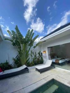 a patio with a swimming pool and a house at UMARA villa bali x villa aydin kerobokan bali in Seminyak
