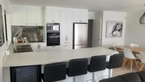 a kitchen with white cabinets and a white counter top at Dewdrop Cottage in Hastings