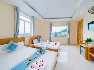 a hotel room with two beds and a window at Làng Chài Hotel & Restaurant in Cat Ba