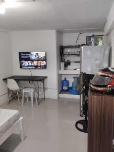 Zimmer mit einem Tisch, einem Tisch und einem Schreibtisch in der Unterkunft Vin's Place Rentals - Studio Unit in Tagum