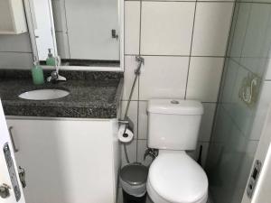 ein Badezimmer mit einem WC, einem Waschbecken und einem Spiegel in der Unterkunft Quarto no Dubai Residence in São Luís