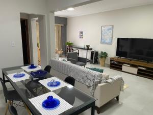 a living room with a table and chairs and a television at Apartamento no centro de São Lourenço 100% reformado in São Lourenço