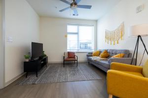 a living room with a couch and a tv at Modern Nulu 2BR CozySuites 01 in Louisville
