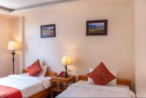a hotel room with two beds and two lamps at Thu Hang Sapa Hotel - by Bay Luxury in Sa Pa