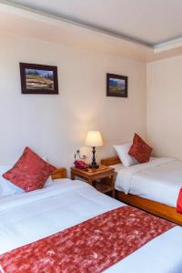 a room with two beds and a table with a lamp at Thu Hang Sapa Hotel - by Bay Luxury in Sa Pa