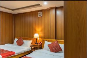a bedroom with two beds and a table with a lamp at Thu Hang Sapa Hotel - by Bay Luxury in Sa Pa +7 photos