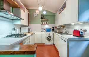 a kitchen with white cabinets and a washer and dryer at Beautiful Apartment In Monte San Savino With Kitchen in Monte San Savino