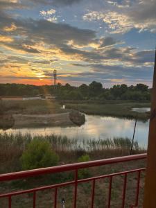 d'un balcon offrant une vue sur la rivière au coucher du soleil. dans l'établissement Pond Side, à Fier