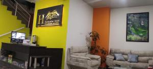 - un salon avec deux chaises et un mur jaune dans l'établissement BACKWATER HOTEL, à Ipiales