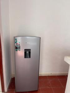 um frigorífico prateado num canto de um quarto em Apartamentos Cupules em Mérida