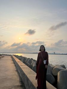 een vrouw die naast het water op een pier staat bij De V’Charm Hotel in Ðông Tác (1)