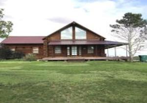 a large wooden house with a large grass yard at Log Haven in Blanding in Blanding