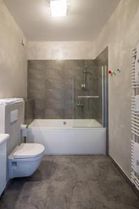 uma casa de banho com uma banheira, um WC e um chuveiro em Vigo Hotel em Łódź