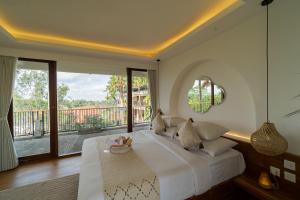 a bedroom with a large bed and a balcony at Om Ham Retreat and Resort in Ubud +37 photos