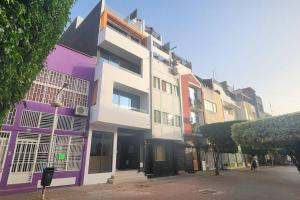 普拉亚Kingfisher 2A and Seagull 4A Plateau Apartments on Rua Pedonal Praia Cape Verde的城市街道上的白色和紫色建筑