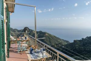 a balcony with tables and chairs on top of a mountain at La Finestra sul Mare a Drignana (5Terre, Vernazza) in Vernazza