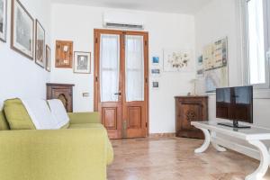 a living room with a yellow couch and a tv at La Finestra sul Mare a Drignana (5Terre, Vernazza) in Vernazza