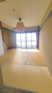 an empty room with a large window and a chandelier at Guest House Gamigami in Onomichi