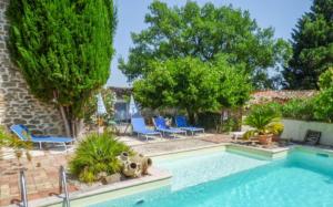 Saint-Sauveur-de-Cruzières的住宿－Chambre Voltaire，一个带蓝色椅子和树木的游泳池