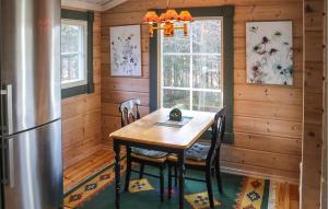 a dining room with a table and a refrigerator at Gorgeous Home In Fjlkinge With Kitchen in Fjälkinge