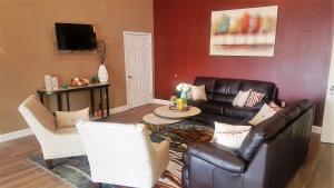 a living room with a leather couch and chairs at Red Roof Inn & Suites Houston – Humble/IAH Airport in Humble