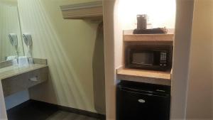 a small kitchen with a microwave and a sink at Red Roof Inn & Suites Houston – Humble/IAH Airport in Humble