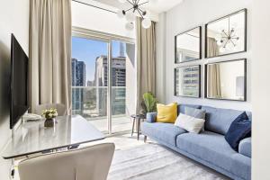 a living room with a blue couch and a large window at Silkhaus large studio with bedroom in Business Bay's new tower in Dubai