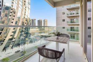 einen Balkon mit einem Tisch und Stühlen sowie einem großen Fenster in der Unterkunft Silkhaus Business Bay in new Building Large studio with bedroom in Dubai