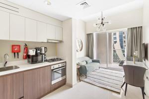 eine Küche und ein Wohnzimmer mit einem Sofa und einem Tisch in der Unterkunft Silkhaus Business Bay in new Building Large studio with bedroom in Dubai