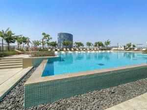 uma piscina com água azul num resort em Silkhaus 1BDR in Dubai Hills with pool access, very bright em Dubai